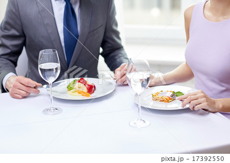 close up of couple eating appetizers at restaurant 17392550