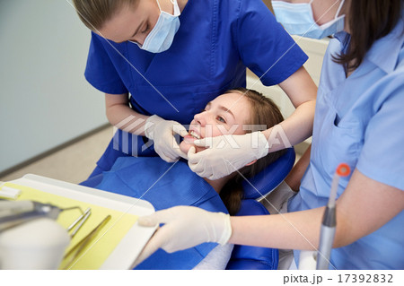 happy female dentist with patient girl at clinic 17392832