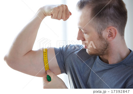 close up of male hands with tape measuring bicep 17392847