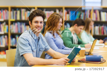 happy student boy reading books in library happy student boy reading books in library 17392917