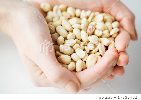 close up of woman hands holding peeled peanuts 17393752