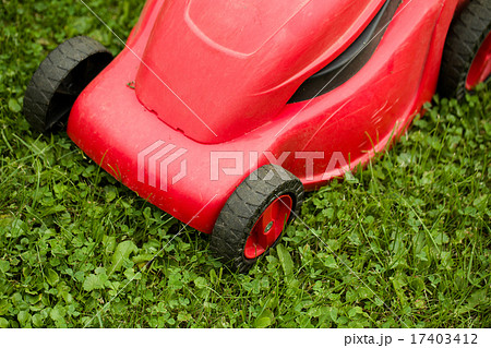 red lawnmower on green grass 17403412