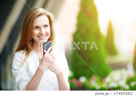 Young pretty woman with mobile phone. City defocusrd background. Young pretty woman with mobile phone. City defocusrd background. 17405882