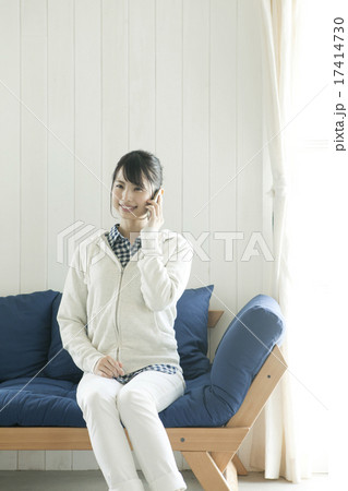 ソファに座って電話をする若い女性 17414730
