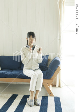 ソファに座ってスマホを操作する若い女性 ソファに座ってスマホを操作する若い女性 17414798