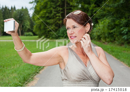 Woman in Gown Taking Self Portrait with Cell Phone Woman in Gown Taking Self Portrait with Cell Phone 17415018