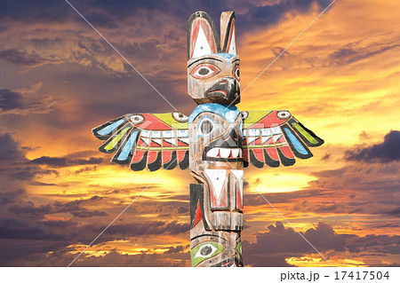 Totem wood pole in the gold cloudy background Totem wood pole in the gold cloudy background 17417504