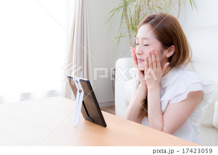 家で鏡を使ってお手入れする女性　 17423059