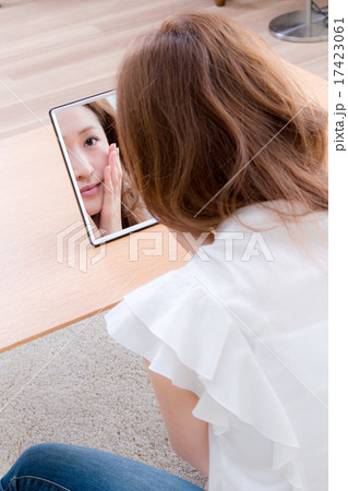 家で鏡を使ってお手入れする女性　 17423061