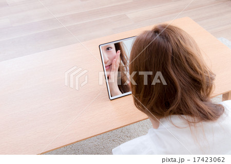 家で鏡を使ってお手入れする女性　 17423062