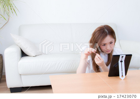 家で鏡を使ってお手入れする女性　 17423070