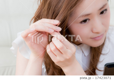 家で鏡を使ってお手入れする女性　 17423071