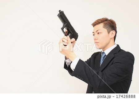 銃を構える若いビジネスマンの写真素材