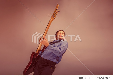 teenager boy brown hair of European appearance playing guitar fe 17428707
