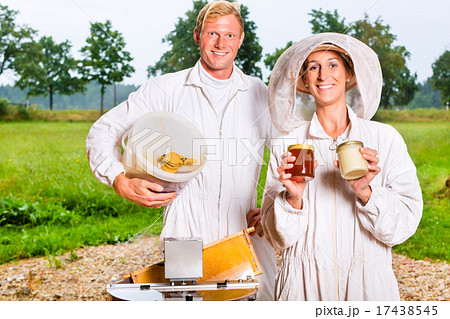 Beekeeper filling honey with extractor in glass Beekeeper filling honey with extractor in glass 17438545