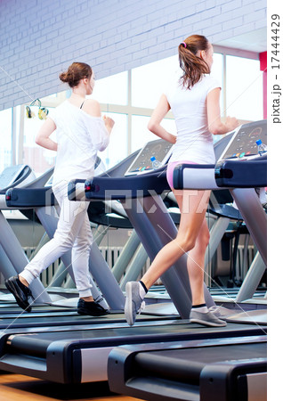 Two young sporty women run on machine 17444429