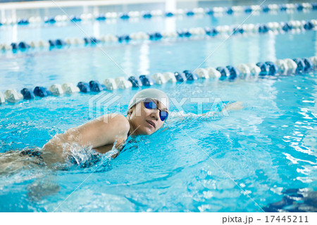 Young girl in goggles swimming front crawl stroke style 17445211