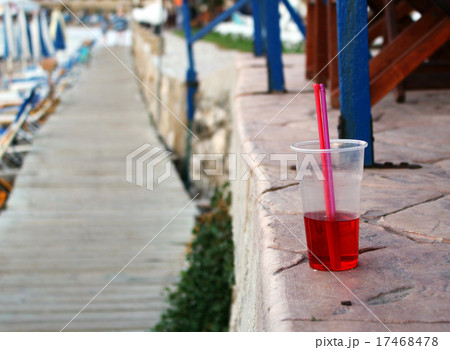 Cold red drink with straw at the beach 17468478