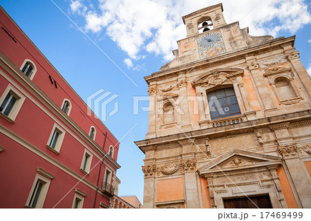 Church with wall clock and old red house facade 17469499