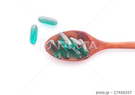 Pills capsule on wooden spoon isolated 17488207