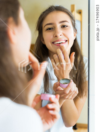 Teenager applying lipstick 17496903