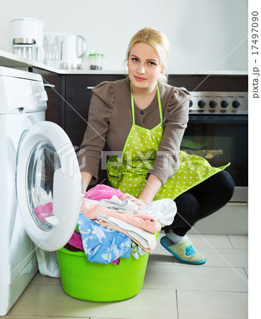 Unhappy girl using washing machine Unhappy girl using washing machine 17497090