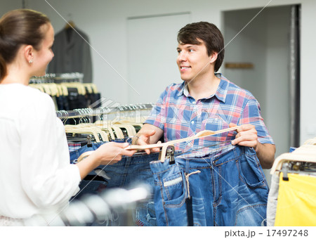 Happy pair choosing jeans in store 17497248