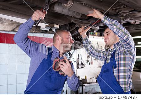 Two people fixing car 17497437