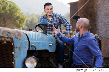 Farmers near agricultural machinery Farmers near agricultural machinery 17497479