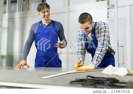Two careful workmen cutting glass for windows Two careful workmen cutting glass for windows 17497519