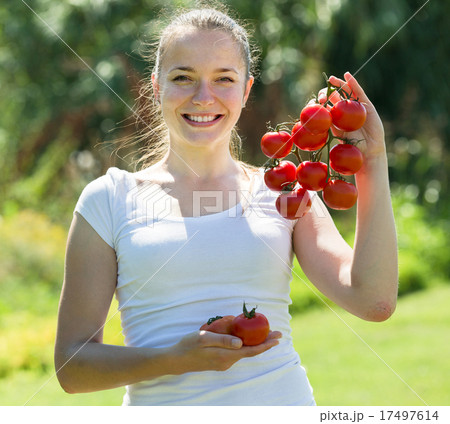 Young woman with tomato in garden Young woman with tomato in garden 17497614