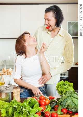 happy couple with vegetables in home kitchen 17497976