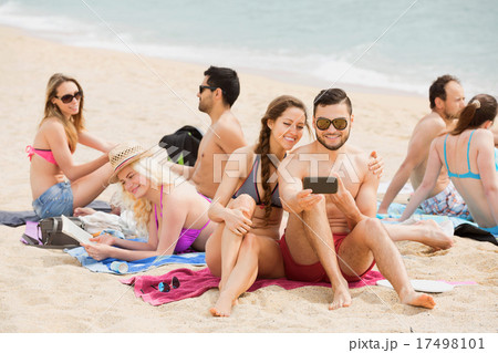 Smiling friends doing selfie at sea shore Smiling friends doing selfie at sea shore 17498101