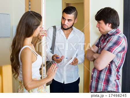 banker and couple talks in doorway 17498245