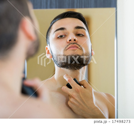 Young guy using perfume at home. 17498273