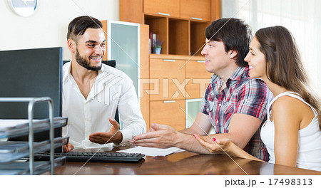 Couple and manager talking about purchase in the office 17498313