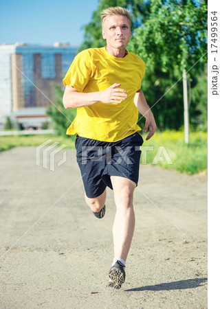 Sporty man jogging in city street park. Outdoor fitness. 17499564