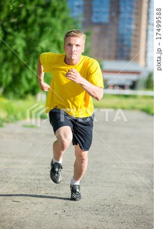 Sporty man jogging in city street park. Outdoor fitness. 17499588