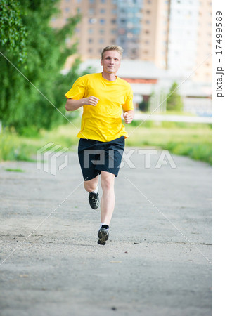 Sporty man jogging in city street park. Outdoor fitness. 17499589