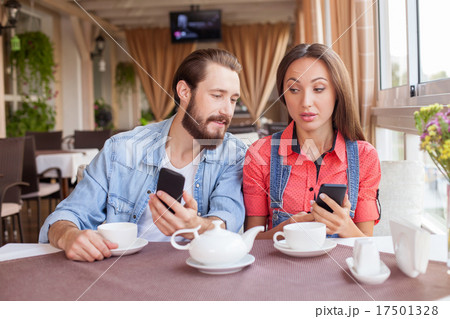 Pretty man and woman are using telephones is Pretty man and woman are using telephones is 17501328