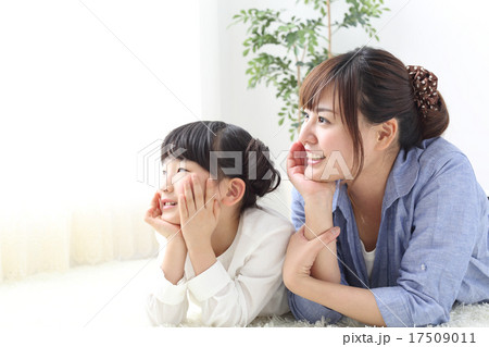 窓の外を眺める母親と娘 17509011
