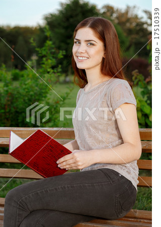 Attractive girl with a diary sitting on the bench Attractive girl with a diary sitting on the bench 17510339