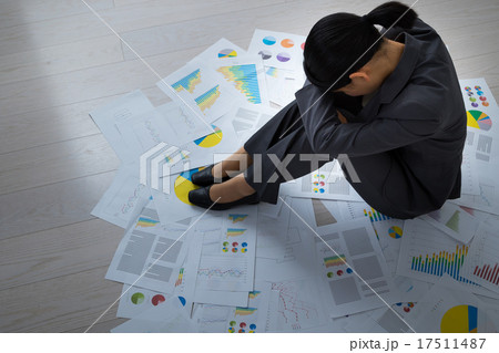 女性　疲労困憊　ブラック企業　疲れ　憂鬱　大量の資料　エンジニア　OL　オフィスレディ　膝を抱える 17511487