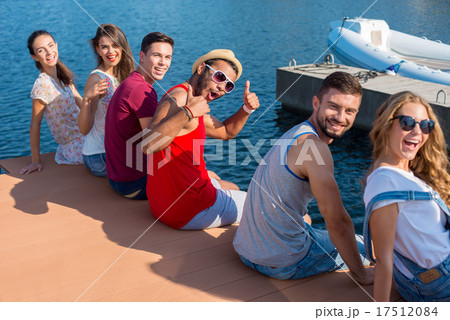 Young people is resting on the quay.  17512084