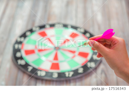 Hand holdin red arrow and throwing to dart board 17516343