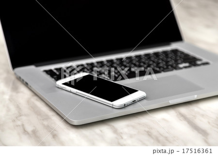 laptop with smart phone on table 17516361