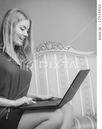 Fashion woman sitting on sofa using pc laptop 17534950