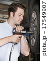 Mechanic In Garage Using Air Hammer On Car Wheel 17549907