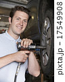Mechanic In Garage Using Air Hammer On Car Wheel 17549908