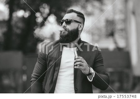 man with a beard smokes electronic cigarette man with a beard smokes electronic cigarette 17553748